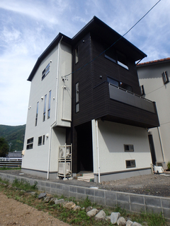 土地の広さを活用するための三階建に。白と黒のコントラストは存在感を出しながらも威圧感を与えない