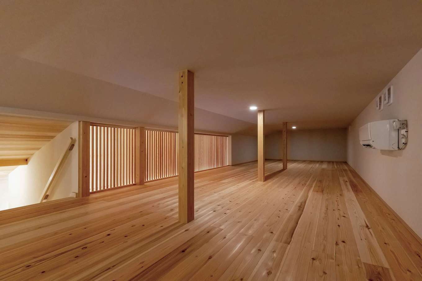 住まいるコーポレーション【自然素材、省エネ、平屋】階段で上がる小屋裏収納は、天井は低いものの、住まい手自身で居心地の良い空間を造り、楽しむことができる。また、大型の季節物を収納したりと便利。格子で明るさと換気も確保し、夏はこのエアコン1台で家じゅうに冷気を送り込むことができる