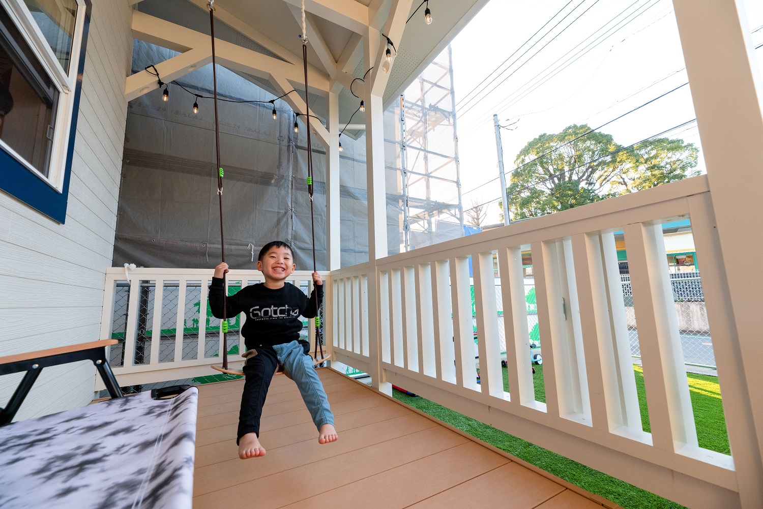 irohaco （アヴァンス）【デザイン住宅、省エネ、インテリア】カバードポーチに付けたブランコで遊ぶ長男。雨の日も退屈しない