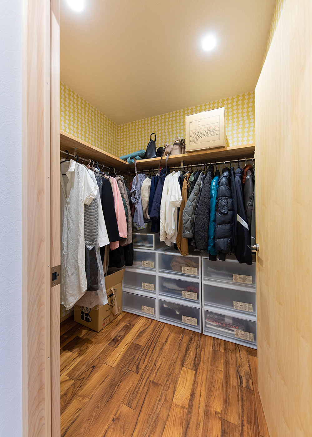 櫻 工務店【自然素材、狭小住宅、間取り】二人の娘さんたちが成長した時のことを考え、収納力のあるファミリークローゼットを。暗くなりがちな収納も北欧テイストの壁紙でキュートに