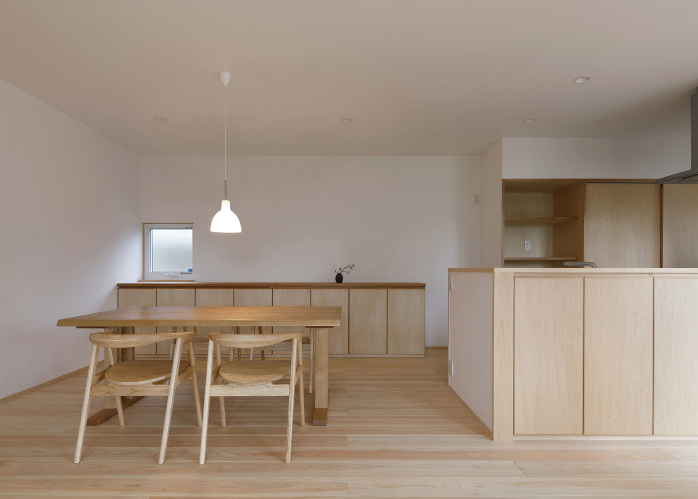 灯建築舎【デザイン住宅、和風、自然素材】奥のキッチンボードや家電収納、食器棚はすべて造作。空間の統一感がもたらされ、スッキリとした印象が保たれる。カウンターは手元が見えない高さで、手前側は収納になっている