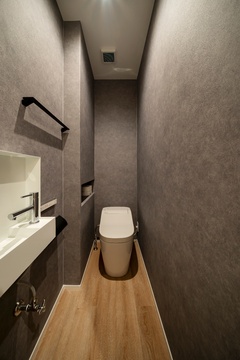 シンプルかつモダンなデザインのトイレ。落ち着いた色調が空間に優雅さをプラスし、リラックスした雰囲気を演出する。