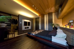 夫妻の寝室はアジアンリゾートな雰囲気。ＴＶを設置した壁の奥をウォークインクロゼットにするなど、ホテルライクなつくりになっている