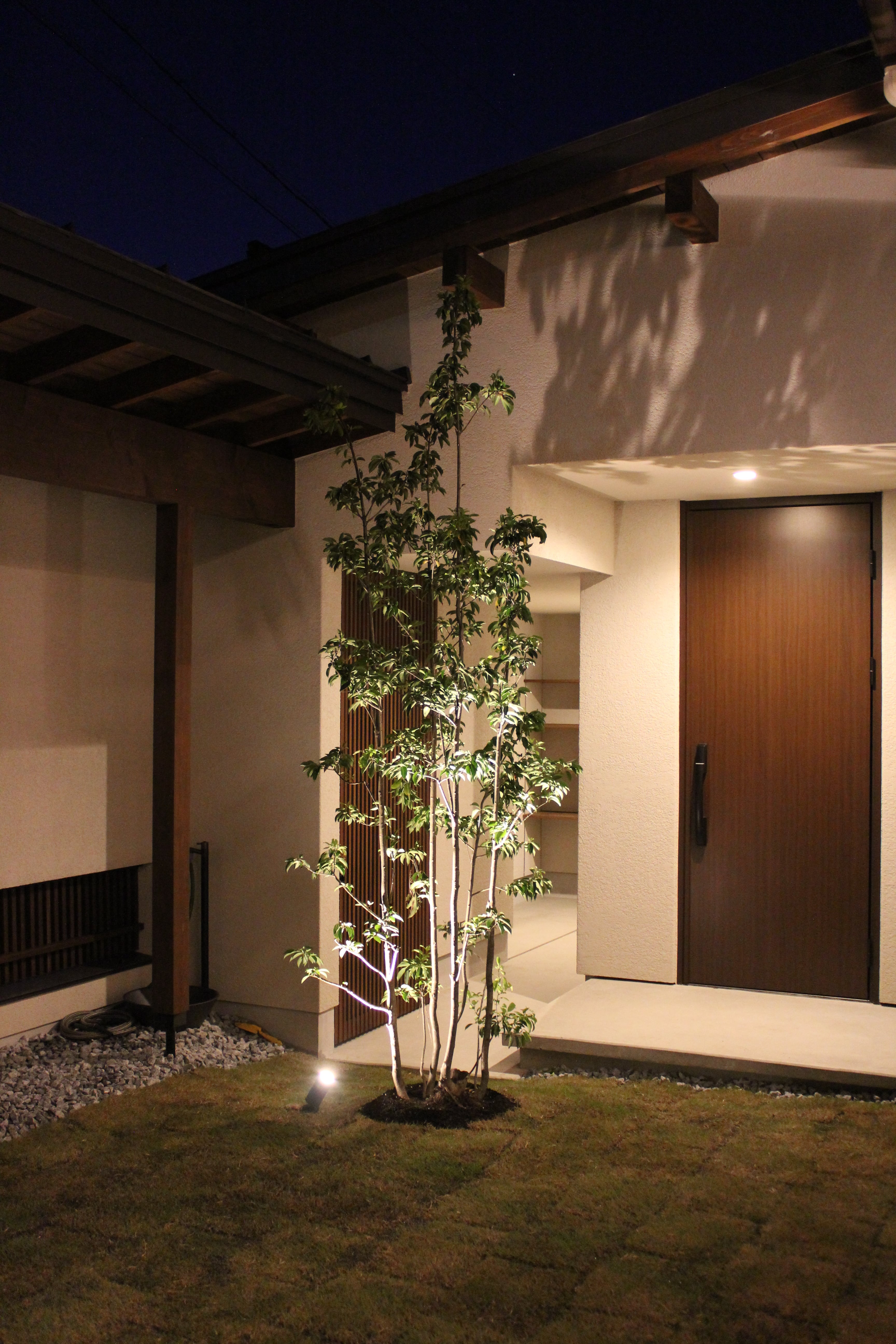 安田住宅｜安田建築設計室｜温かみのあるライトアップが印象的な夜の外観。シンプルなたたずまいが、落ち着いた雰囲気を演出している。