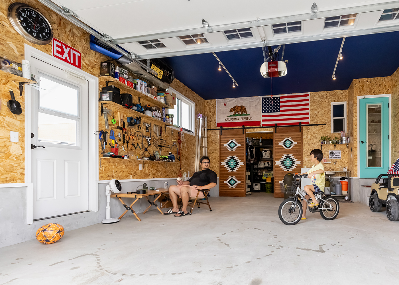 ジェネラルアメリカンホーム【デザイン住宅、輸入住宅、平屋】アメ車と軽自動車を格納できる広いビルトインガレージ。奥にはたくさんの釣り竿やキャンプ用品をしまえる収納スペースを設けている。パントリーに直結しているので、雨に濡れることなく出入りができるので便利