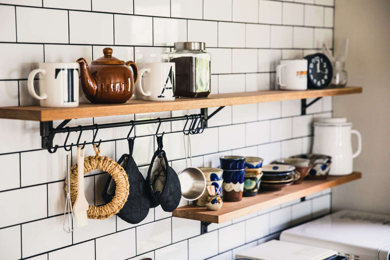 ALAIN（アラン）｜「この家に住むようになってから食器選びにこだわるようになりました」と微笑む奥さま。“見せる収納棚”に、ぽってりとした沖縄の食器が慎ましやかに並ぶ。子育てに追われる慌ただしい日々の中でも、ていねいな暮らしを楽しんでいるのが素敵