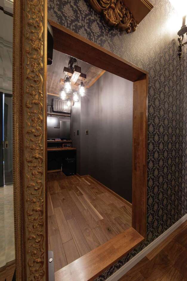 廊下の全身鏡をスライドさせるとご主人の隠し部屋が。自ら塗装して地下室のような雰囲気に仕上げた