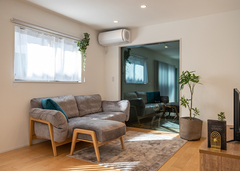 20畳のLDK。大開口の透明ガラス越しにガレージ内のバイクがライトアップされ、リビングから眺められるようになっている