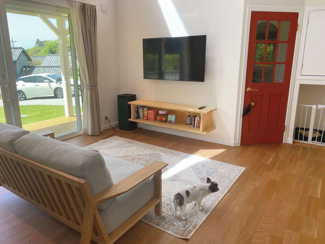 メープルホームズ伊豆 (吉村工務店)【デザイン住宅、輸入住宅、平屋】造作のテレビボード。リビングからはデッキに出られる。赤色でポップなかわいさを演出