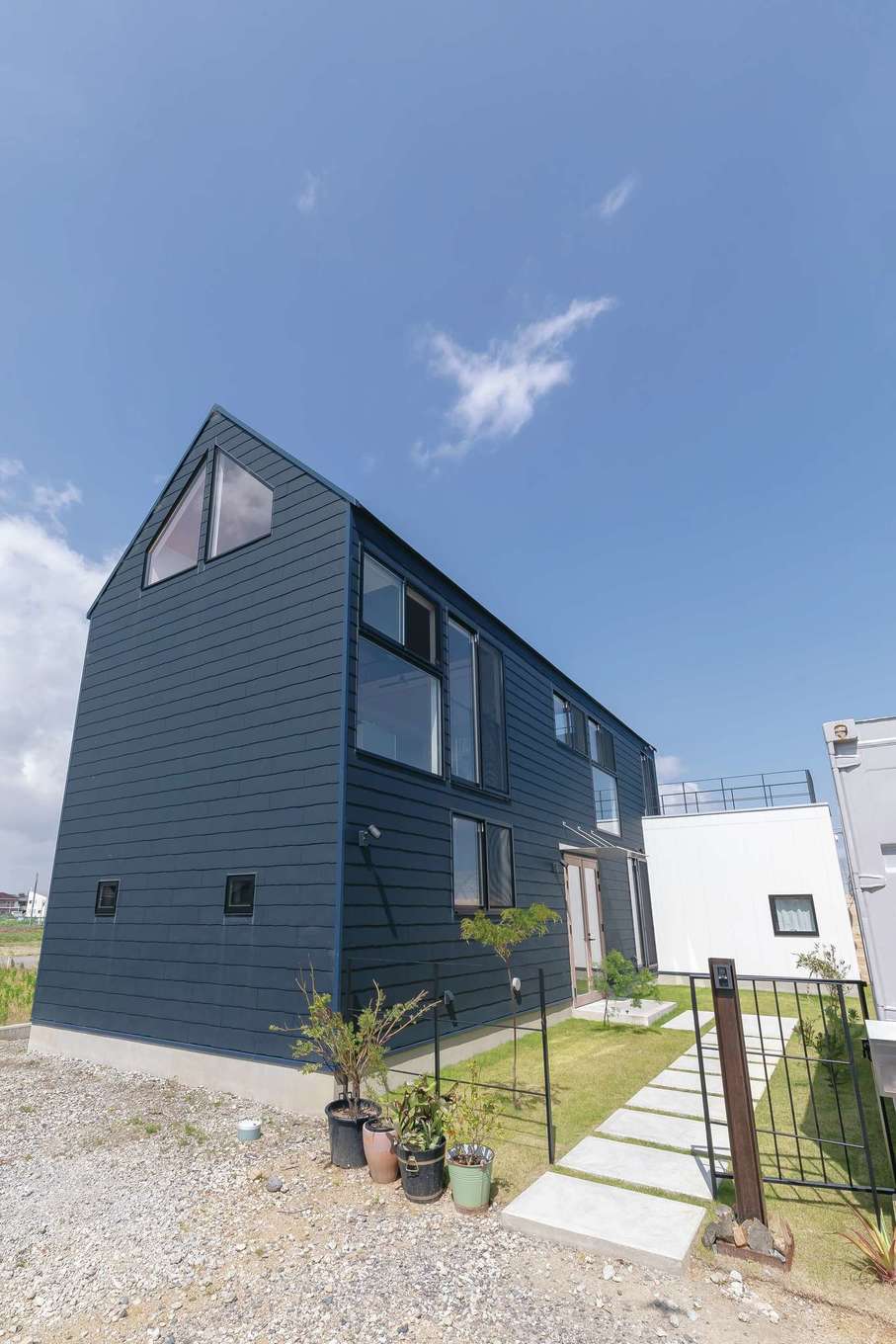 MABUCHI【デザイン住宅、建築家、インテリア】陶器のような風合いと波形デザインが調和した外観が住まい手の個性を引き出す。敷地内にはコンテナハウスもある