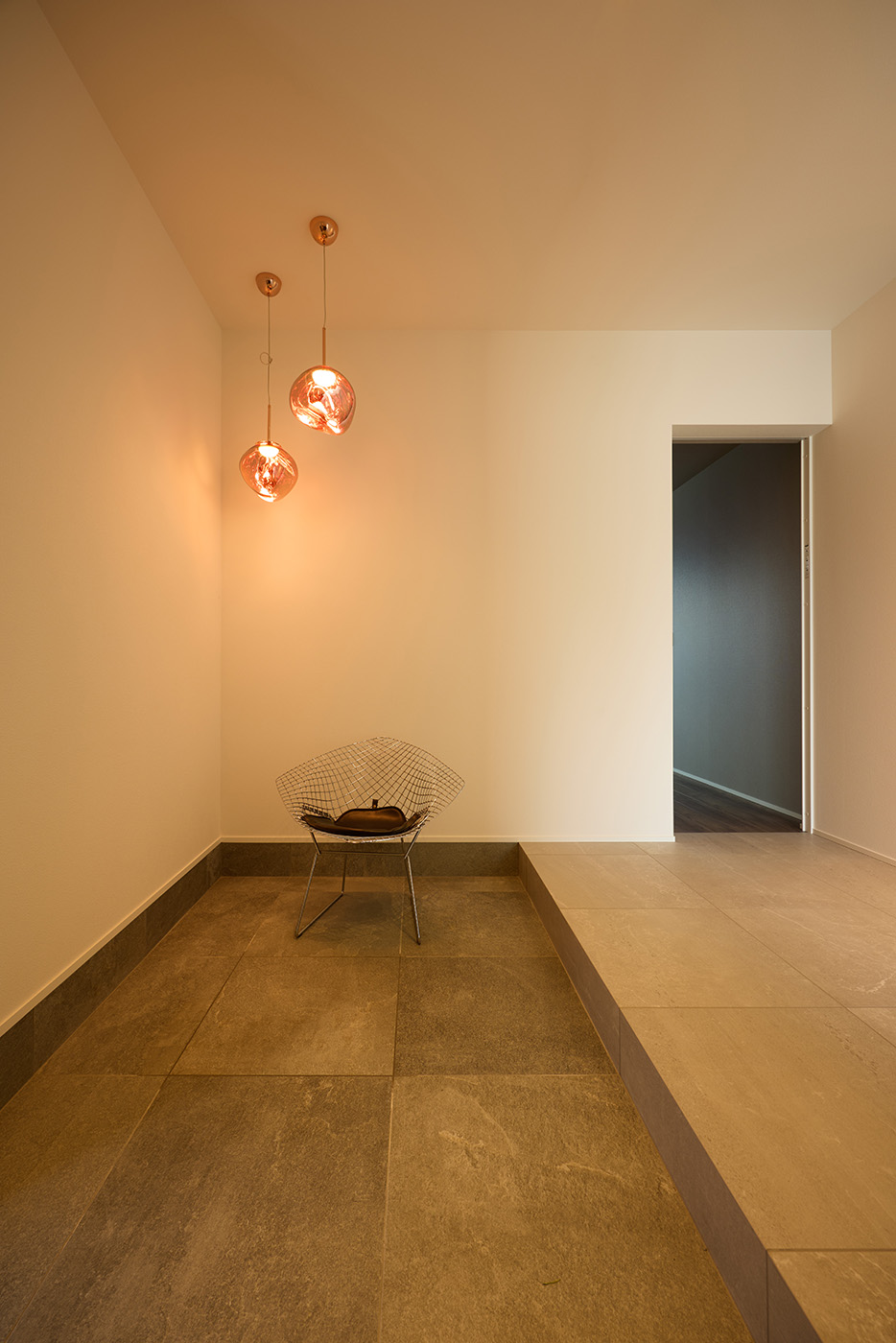 la CASA（ラ・カーサ）【デザイン住宅、平屋、インテリア】一部屋ほどの広さがあるエントランスホール。名作チェアを置くスペースや装飾的なペンダントライトを提案した。贅沢なほどの余白スペースが空間にゆとりを与えている