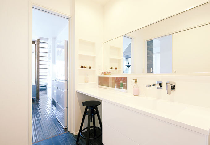 『納得』初のワイドサイズな洗面台。 大きな鏡の前で、家族全員が横に並んで歯磨きできそう。座ってお化粧できるスペースも造作。収納力も抜群！