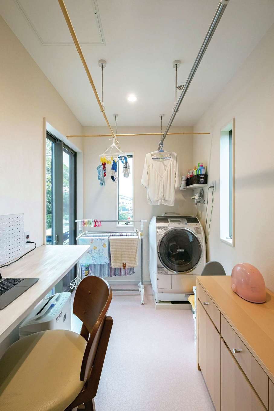 工藤建設【デザイン住宅、子育て、間取り】デッキ横のランドリールームでは、洗う→干す→たたむまでスムーズに完結。家事カウンターでパソコンやアイロンがけもできる