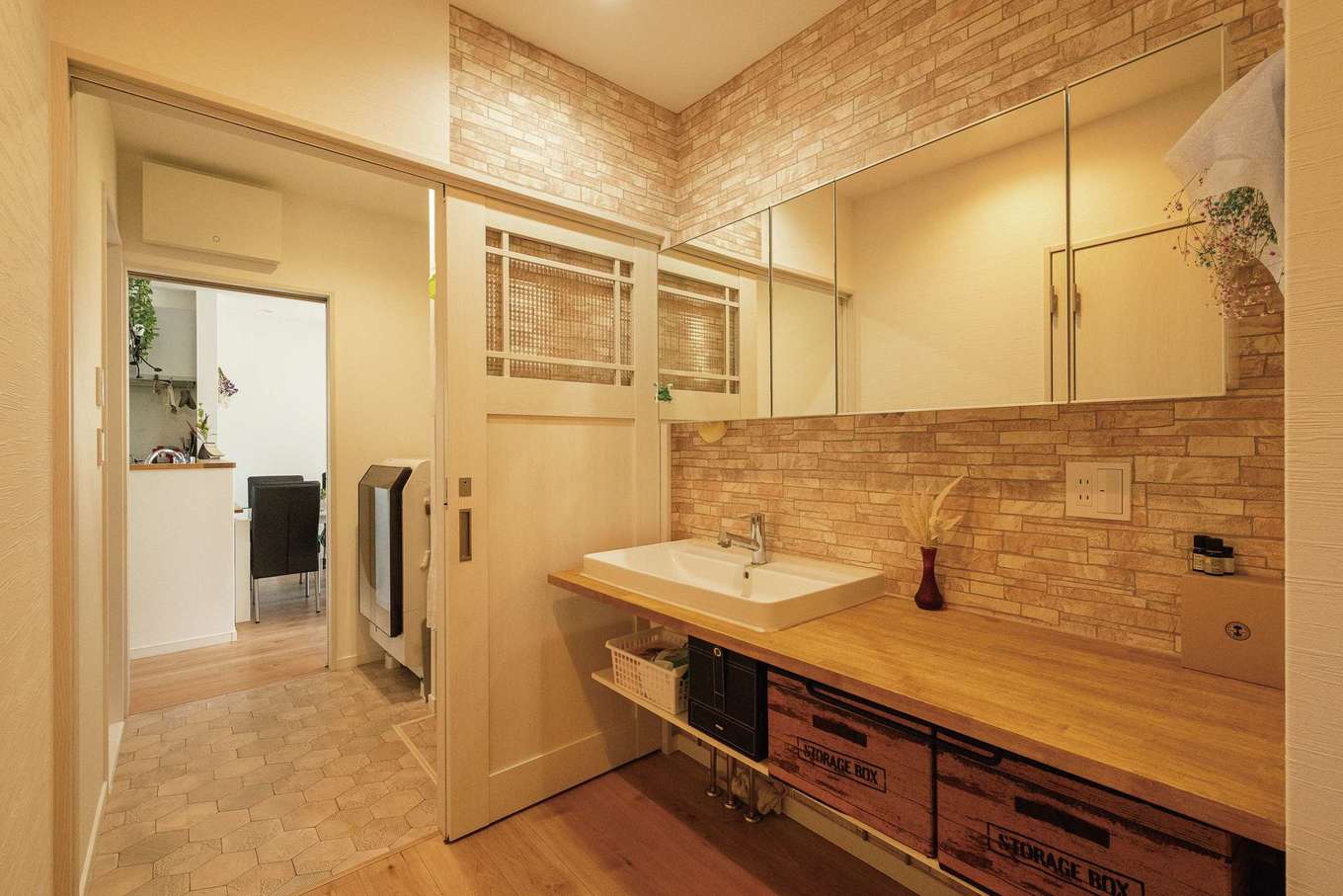 三和建設【趣味、間取り、ペット】キッチン横の建具から脱衣室、洗面室とつながる。一枚板で造作した洗面は奥さまが絵を描いて現場監督に相談。希望した通りの形にできた