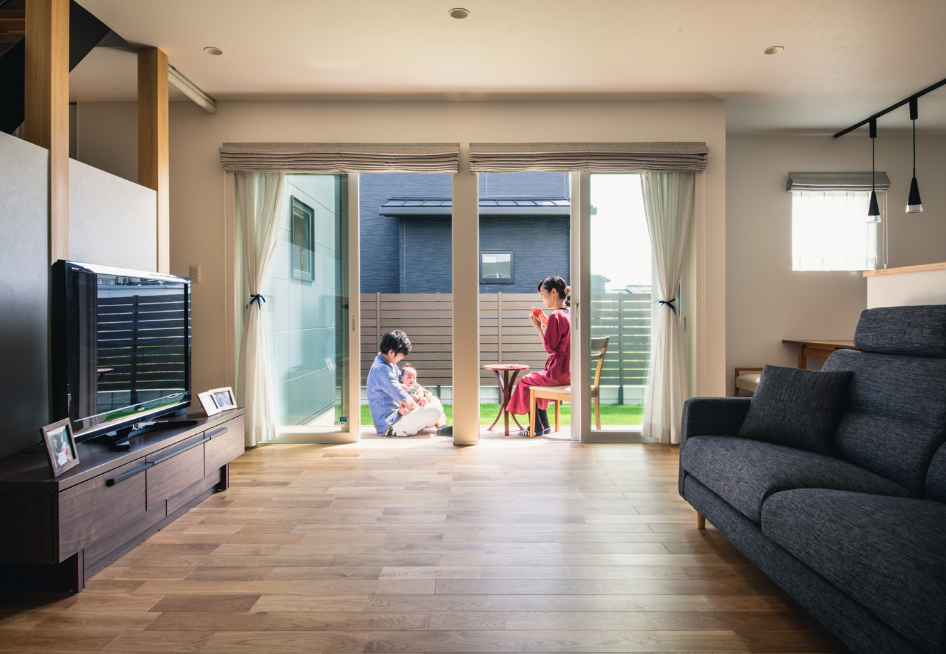 SEIEN ARCHITECT【省エネ、建築家、ガレージ】オークの無垢の床が温かみを感じさせるリビング。ウッドデッキとフラットにつながり、いっそう広々と家族時間を楽しめる