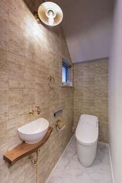 1階のトイレ。壁一面に、戦時中の米軍兵士が妻や恋人に送った手紙を並べたデザインクロスを貼った