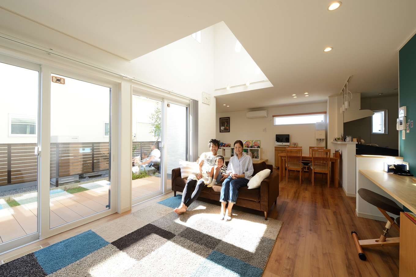 Yamaguchi Design 【デザイン住宅、収納力、間取り】吹抜けを通して、常に家族のつながりを感じあえるLDK。広い庭、縁側のようなウッドデッキと室内が緩やかに結びつき、より広く感じられる