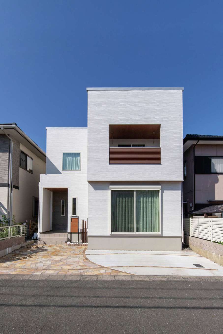 遠州鉄道 遠鉄ホーム【デザイン住宅、省エネ、間取り】白で統一した箱型のフォルムに、バランスよく窓を配置した外観。土地に制約がある中、自宅だけでなく周囲の家の採光や通風にまで配慮して、建物の配置や向き、形状を決めたという