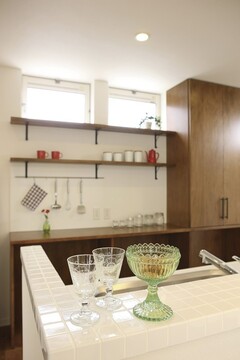 ダークウッドのキャビネットがアクセントのキッチンエリア。収納が豊富