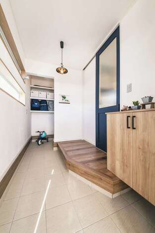 漆喰の壁が上質感をもたらす玄関。土間に奥行きを持たせたことで収納スペースを確保でき、空間に広がりが生まれた