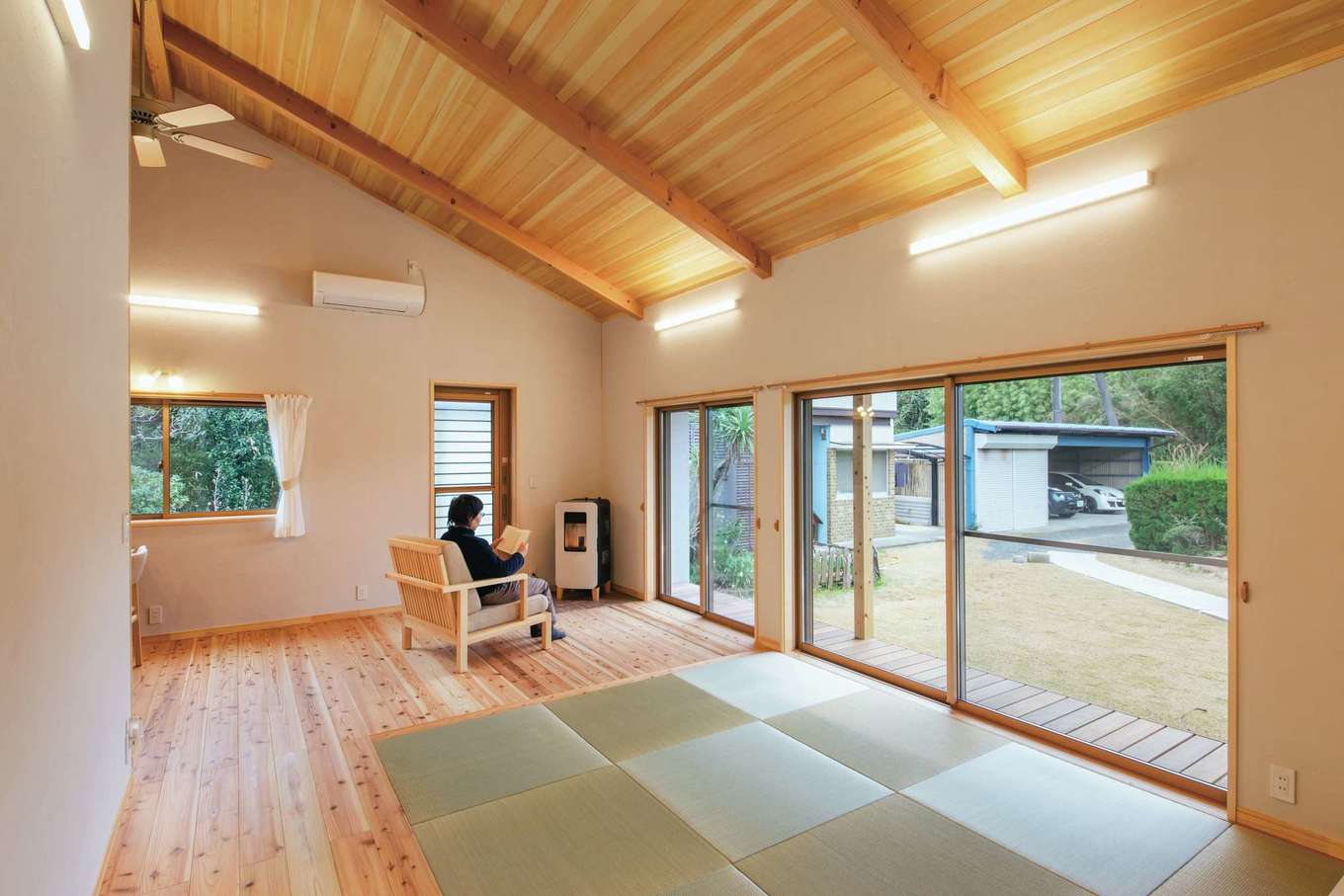 夢スマイル工房【和風、自然素材、平屋】アカマツの板張り天井と浮造りにしたスギの無垢床、そしてシラス塗り壁と自然素材を贅沢に使ったリビング。勾配の板張り天井はご主人の「寝転んだときに木の天井が見えたらいいな」という願いから採用した