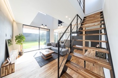 大開口の窓と吹き抜け上のスクエア窓から光が差し込む開放的なLDK。夜はスポットライトや間接照明で居心地のいい空間を演出します。