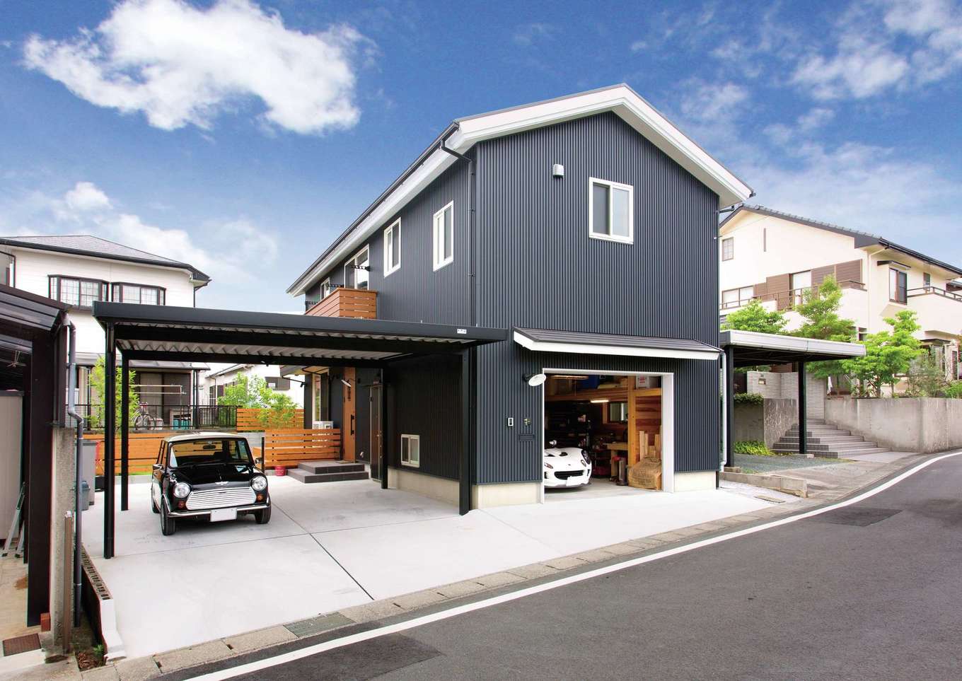 サイエンスホーム【デザイン住宅、ペット、ガレージ】外観のデザインもご主人がラフスケッチを描いた。車を3台所有するため、カーポートとインナーガレージを併設。ダークグレーのガルバリウムに、白い軒天と窓枠が映える