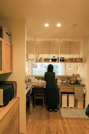 壁に囲まれたキッチンは、玄関側とリビング側の両方から入れる間取り。オーダーキッチンに合わせて、カップボードもフルオーダーで製作してもらった。奥さまが一日の終わりに、キッチンに置いた椅子に座って家計簿をつけるなど、書斎代わりにも使っているそう
