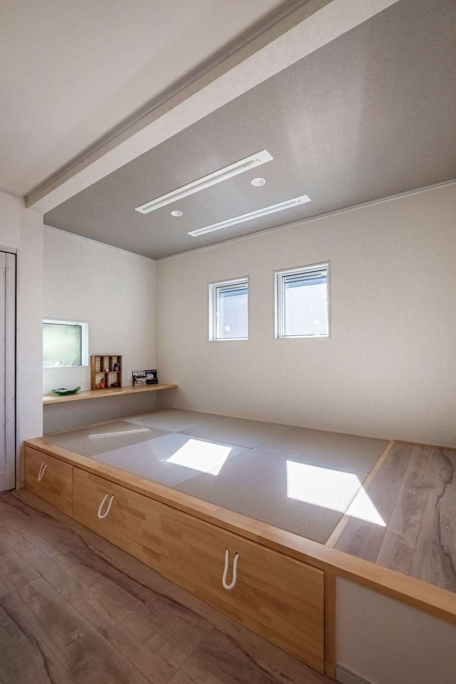 ぽっくハウス【リプルス】【1000万円台、デザイン住宅、子育て】キッチン横の畳コーナーは、LDKとの一体感を意識して和のテイストは控え目に。見学会を参考に小上がりとし、下部には収納を設けた。取っ手代わりのロープは大工さんの提案
