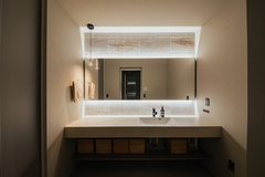 洗面化粧台の壁面にはタイルを貼ることで上質なアクセントと非日常感を演出し、毎日の身支度を心地よく彩ります。機能美と居心地の良さが調和した空間です。