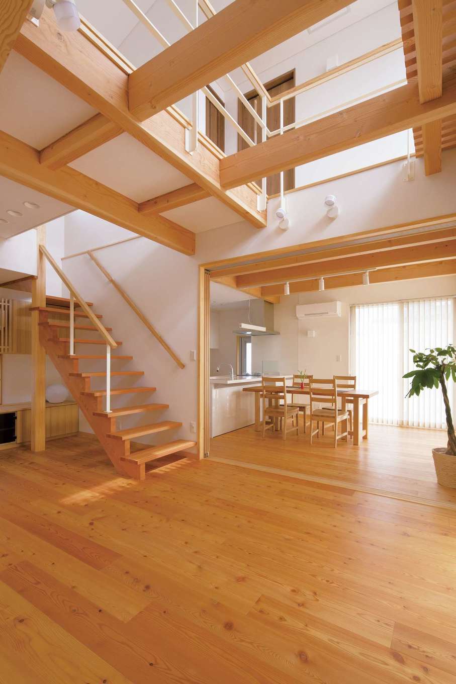 丸洋建設 ハウスオブハウス【自然素材、間取り、デザイン住宅】開放感あふれる吹抜けのリビング。シーンに応じてダイニングと間仕切りも可能。無垢の床は夏はサラッと涼しく、冬は潤いを保ちながらほんのり暖かい。飴色に変化していく経年美も楽しみ