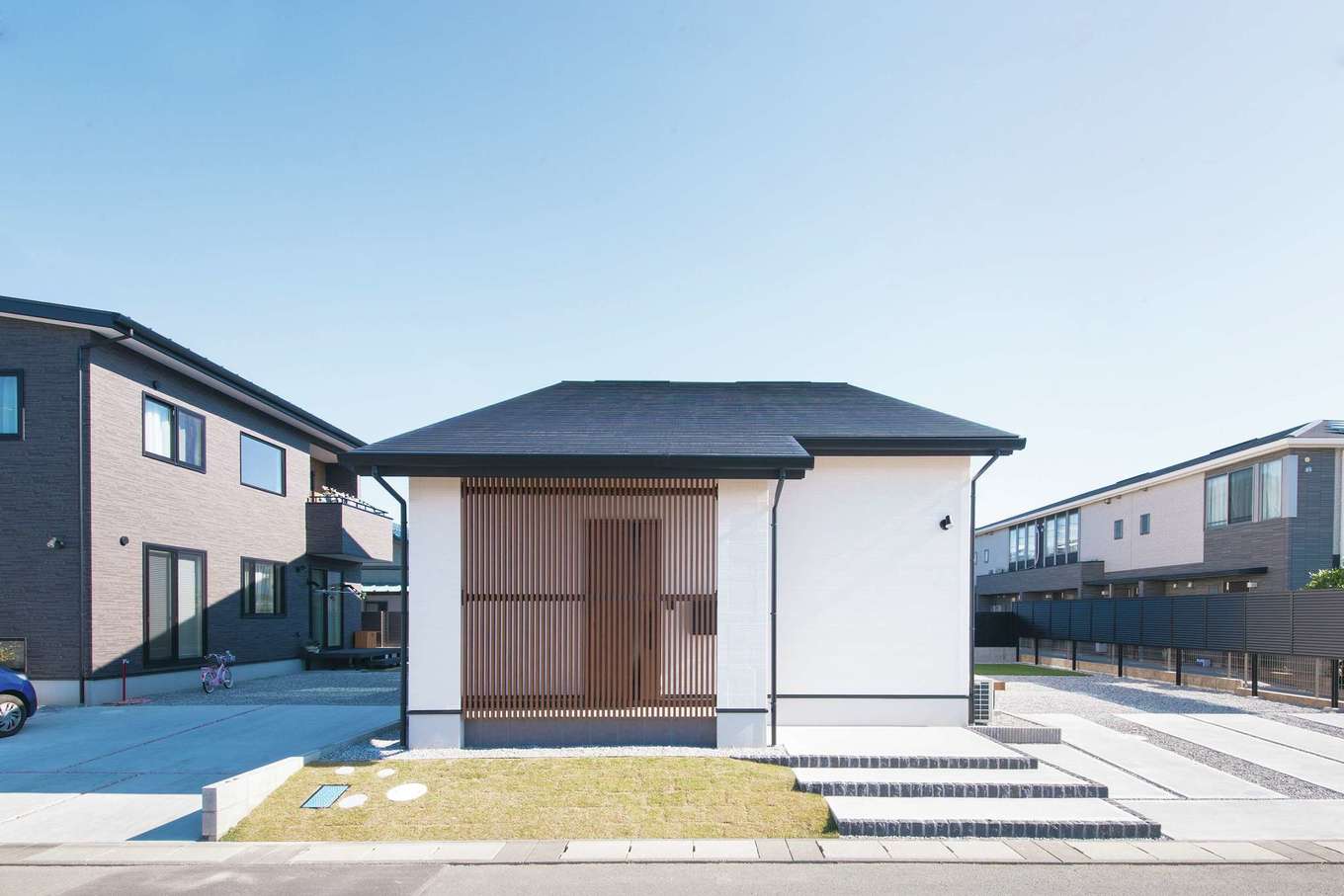 コットンハウス【子育て、省エネ、間取り】端正な縦格子に和の趣を感じるエントランス。外観と内装は色調を揃え、ナチュラルな木の色・白・黒の三色で統一した