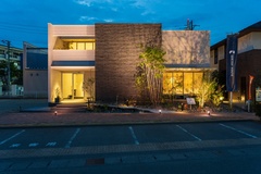 モダンで洗練された外観デザイン。夜間のライトアップによって、建物の立体感と美しさが一層際立つ演出が施されている。