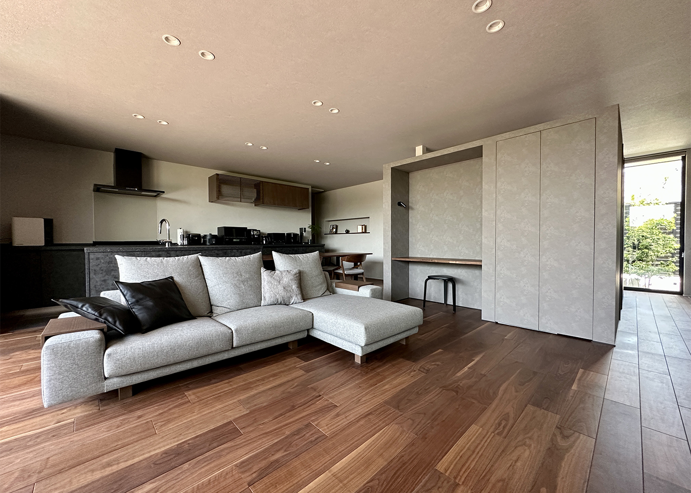 積水ハウス 豊橋支店【デザイン住宅、子育て、平屋】LDKは32.9畳の大空間。これは『積水ハウス』が誇るシャーウッド構法によるもの。木造の家でありながら、高層ビルと同じ程度の強度を確保するという日本で唯一認められた工法で、自然素材の優しさを保ちつつ自由な家づくりを実現する。床はシックな色のウォルナットの挽板。床暖房を導入したので、冬でも足元が暖かい
