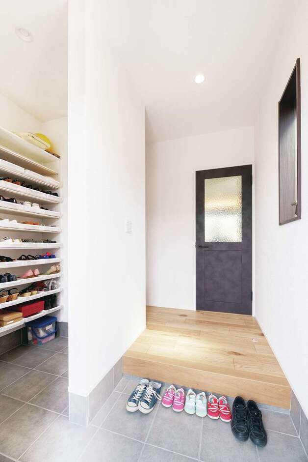 来客用と家族用で動線を分けた玄関。家族用から上がると、その先には洗面・浴室へのドア、さらにキッチンへとつながっている