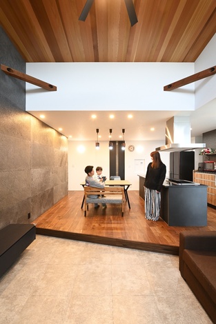 シンプルかつスタイリッシュなデザインのLDK。壁面にはテレビが設置され、家族がリラックスできる広々としたスペースである。