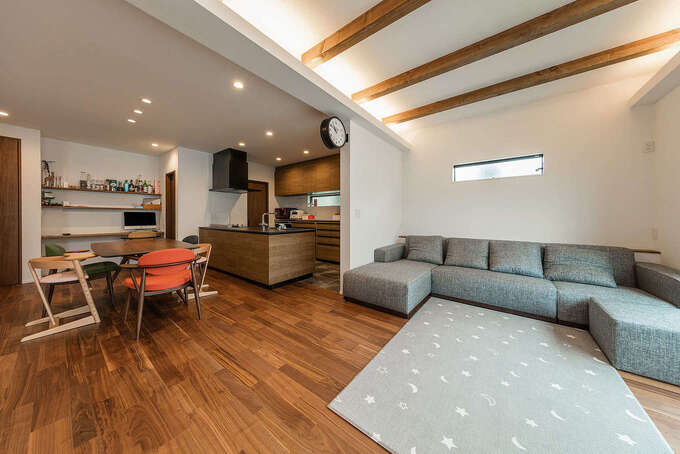 つながりを持たせながら、柔らかくエリア分けされたLDK。ダークブラウンのフローリングに白い壁と天井が映える