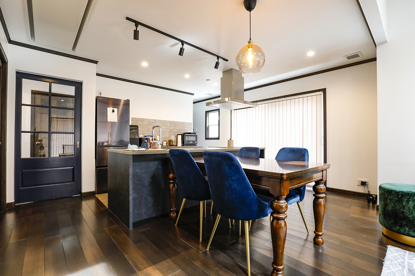 ジェネラルアメリカンホーム【デザイン住宅、平屋、ガレージ】ダイニングキッチンは、ジョリパッド仕上げの壁にダークウッドのモールディングを組み合わせている。建具もダークウッドで統一