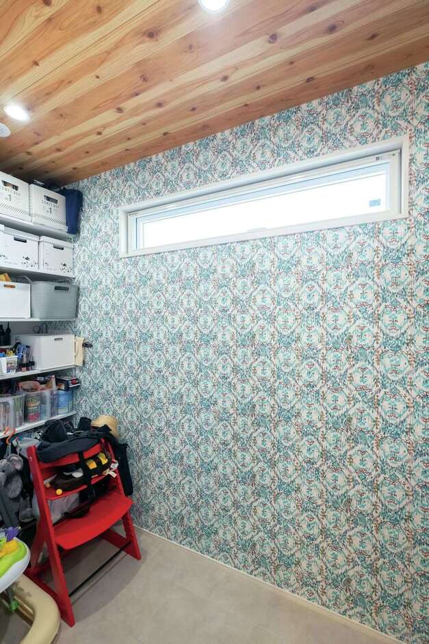 キッチン奥の大容量パントリーは花柄のクロスがアクセント。木目の天井も実は壁紙なのだそう