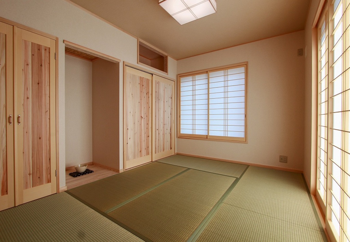 アクトホーム【自然素材、省エネ、間取り】玄関から直接入ることもできる和室。内障子からはやわらかな光を採り込める。収納上部には神棚を設置できるスペースも設けた。
