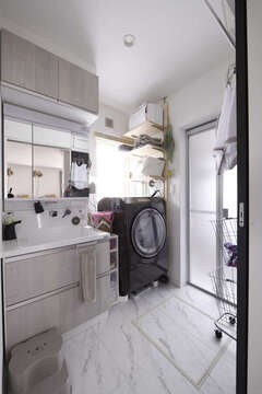 マーブル調の白い床と、薄いグレーの木目の洗面台がベストマッチな洗面・脱衣室。窓があることで、明るく、清潔感にあふれた空間に