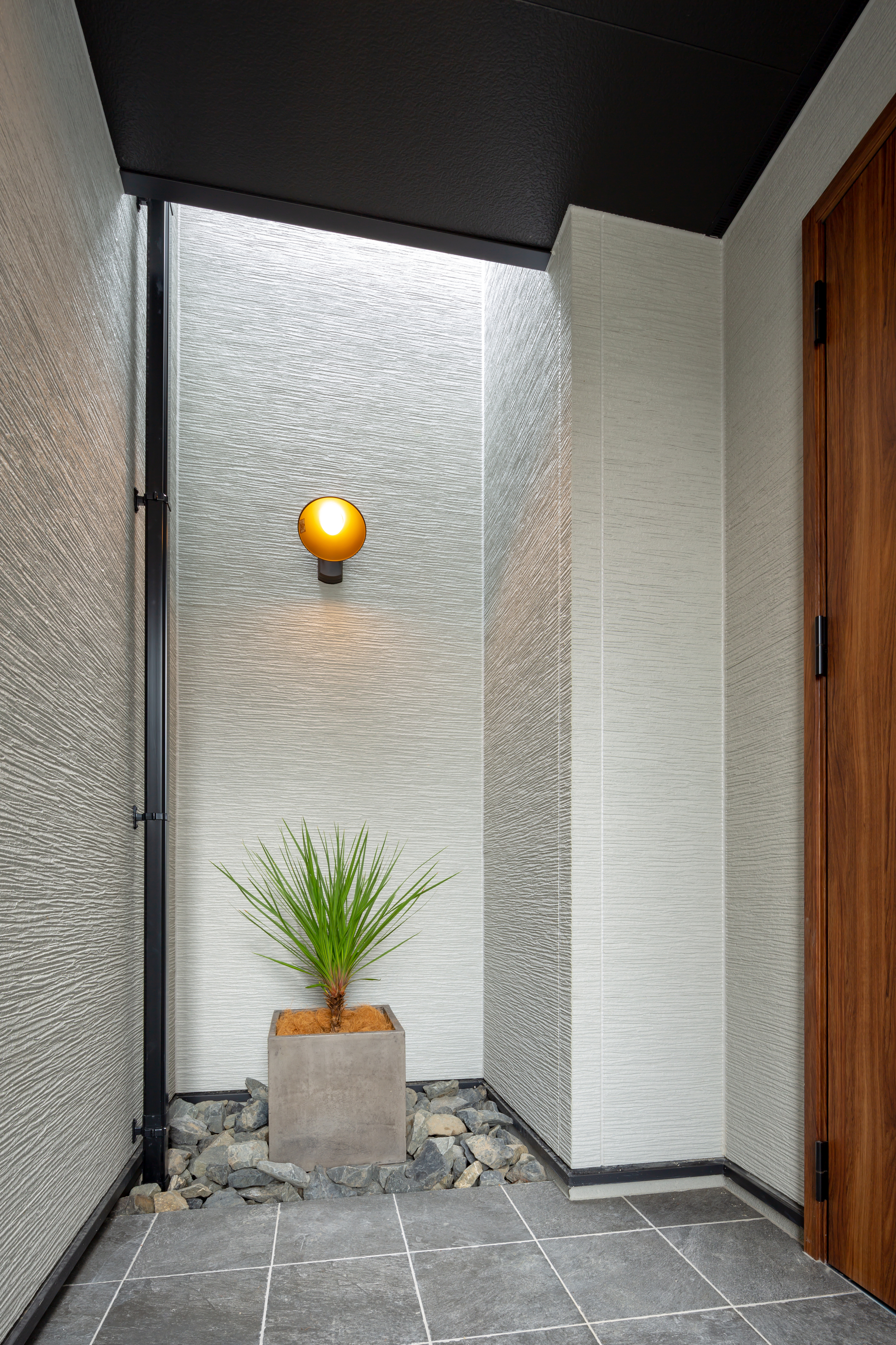 ムニカデザイン（まほろばホーム）｜シンプルで洗練された仕切り壁 落ち着いたカラーの木材や石材を使用し、品のある空間を演出。光を適度に取り込めるデザインで上部吹き抜けに