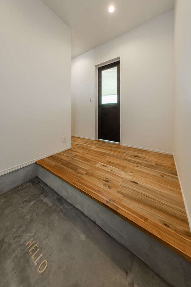 モルタル仕上げの玄関ホール。建具もマットな質感で統一し、大人モダンな高級感を演出した