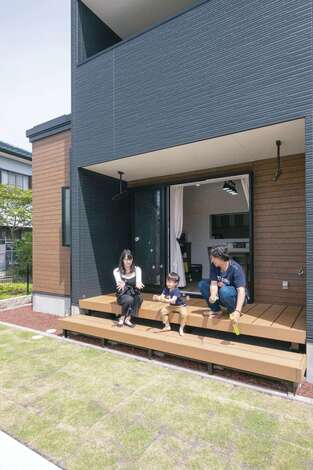 リビングの全開口サッシを開けると、大きなウッドデッキと庭へ。休日はBBQやプール遊びを楽しむ
