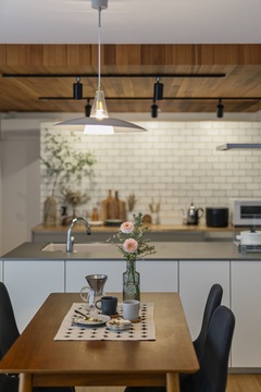 白をベースとした明るい空間に、木目と黒のアクセントを入れたキッチンダイニング。