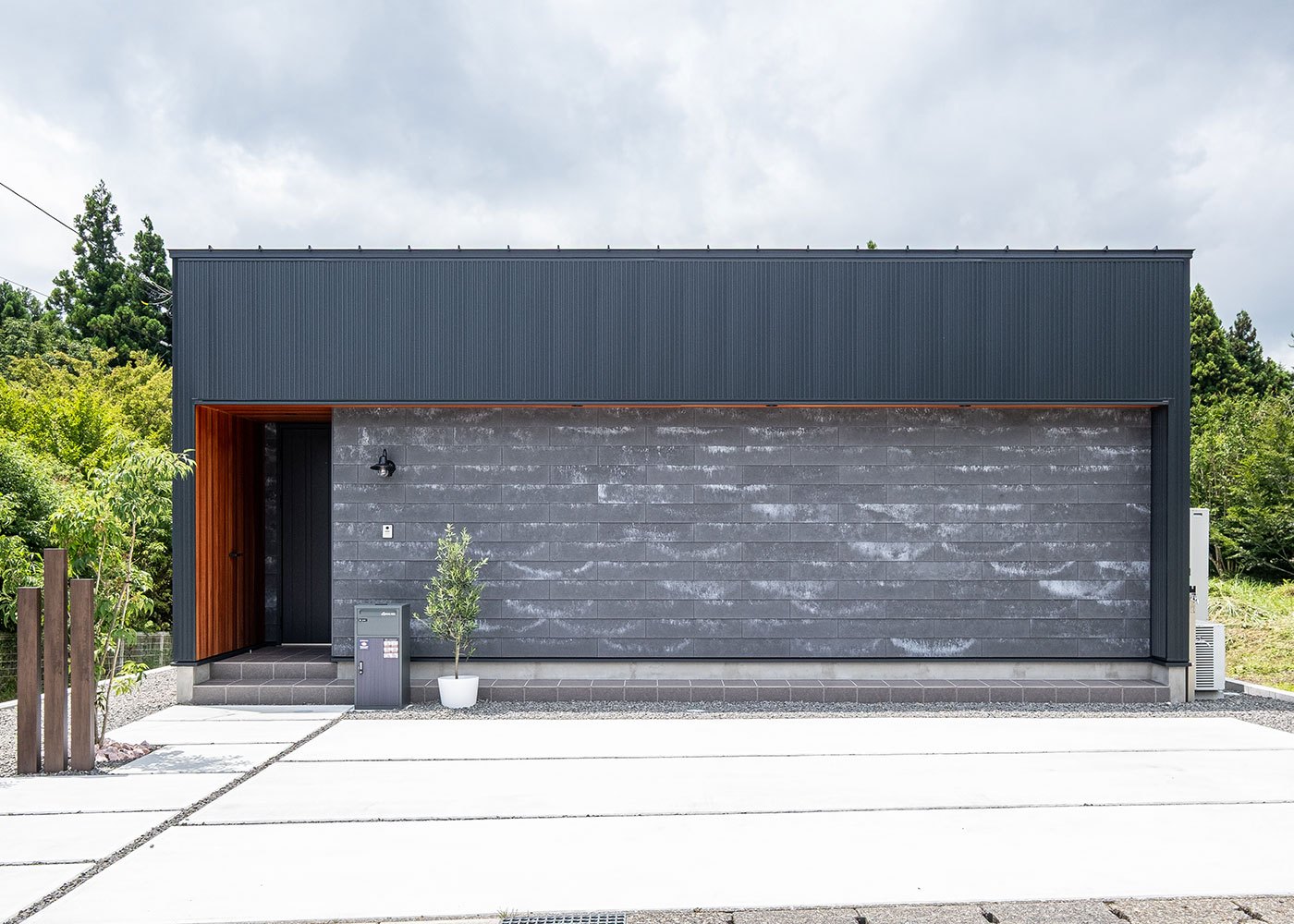 R＋house御殿場（岳南建設）【間取り、建築家、平屋】玄関の軒天井が外観のアクセント。通りに面した窓をなくすことでプライバシーの確保ができ、さらにイニシャルコストの削減に