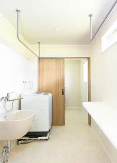 造作カウンターを備えた4畳のランドリースペース。水回りは掃除がしやすいフロアタイルを採用している