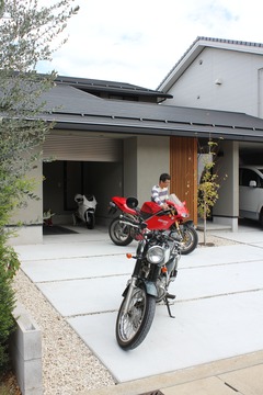 モダンなデザインのバイクガレージ。複数のバイクが余裕を持って格納できる広さで、ガレージライフを楽しむには最適な空間となっている。