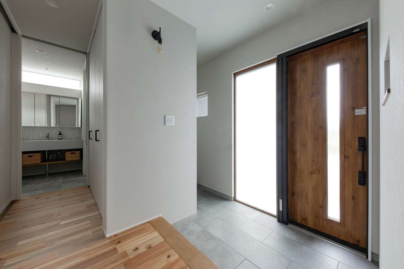 幹工務店【趣味、平屋、ガレージ】シューズクローク付きの玄関。玄関ホールの奥に洗面コーナーがあり、脱衣・浴室、トイレ、ファミリークローク、ランドリー、そして外干し用のデッキへとつながっている