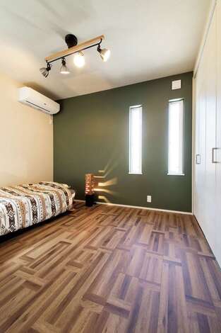 ご主人の寝室はモスグリーンの壁を中心にコーディネート　